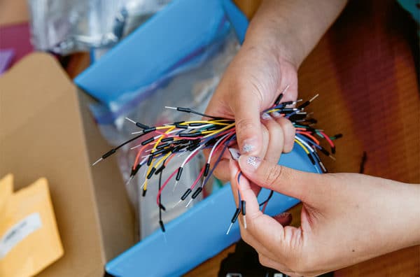 Mains triant des câbles colorés pour projet électronique
