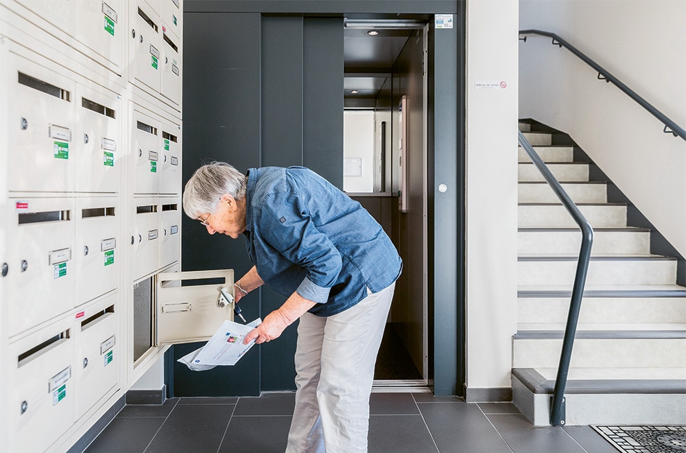Femme âgée vérifiant son courrier dans l'entrée